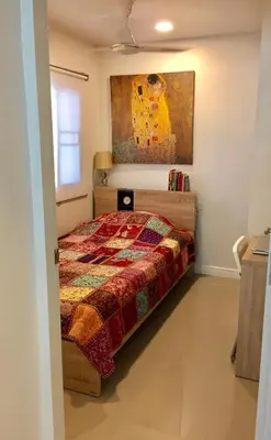 a bedroom with a bed and a painting on the wall at Cozy and Convenient Bangna House in Ban Khlong Samrong