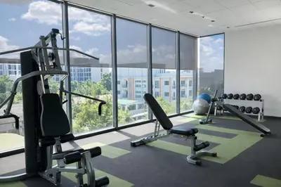 a gym with cardio equipment and a large window at Cozy Japandi Stay on Sukhumvit in Bangkok