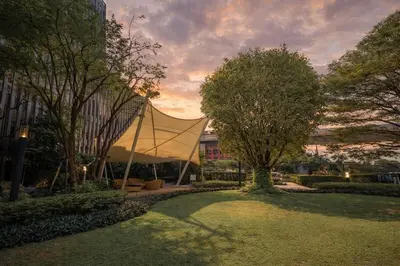 a tent in the middle of a park with trees at Cozy Japandi Stay on Sukhumvit in Bangkok