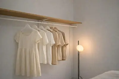 a room with a rack with white shirts and a lamp at Cozy Japandi Stay on Sukhumvit in Bangkok