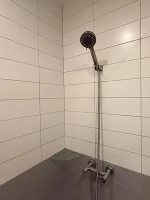 a shower with a shower head in a bathroom at Cozy Japandi Stay on Sukhumvit in Bangkok