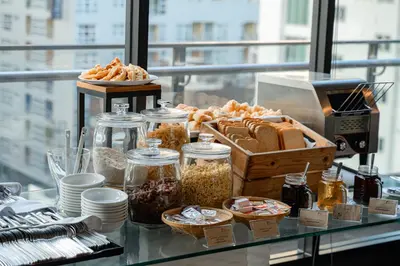 a buffet of food on top of a glass table at Hotel Clover Asoke - SHA Extra Plus in Bangkok