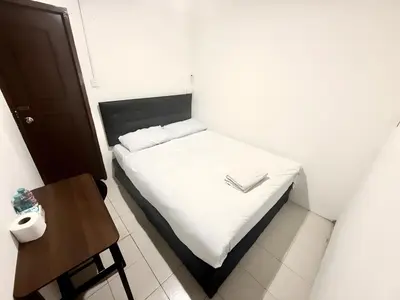 a small bedroom with a white bed and a table at xx zNap Khaosan - แสนป ข้าวสาร รามบุตรี in Bang Bua Thong Railway Station