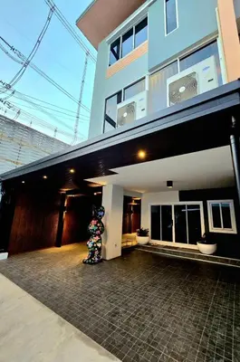 a building with a person standing in front of it at The Atlas hostel Bangkok in Thung Si Kan