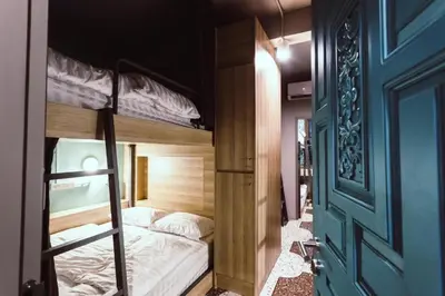 a bedroom with two bunk beds and a door at Merge Hostel in Samphanthawong