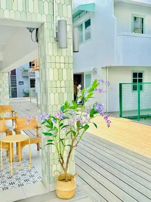 a plant in a basket on the deck of a building at Easy Monday Capsule Bed and Traditional Thai Bath in Bangkok