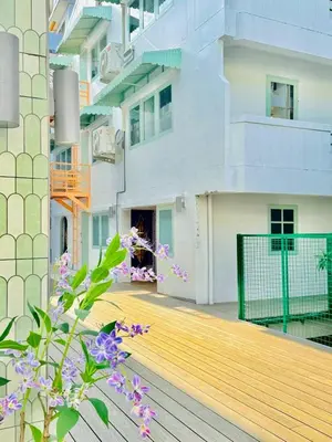 a view from the balcony of a building with purple flowers at Easy Monday Capsule Bed and Traditional Thai Bath in Bangkok