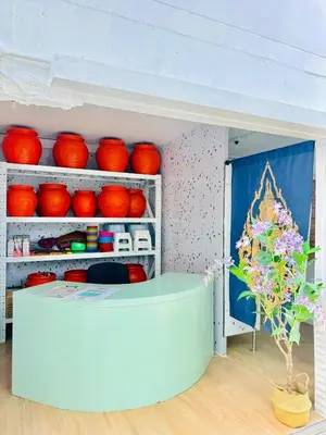 a room with red bowls on shelves and a table at Easy Monday Capsule Bed and Traditional Thai Bath in Bangkok