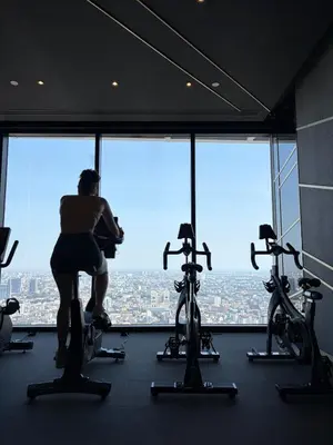 a woman in a gym looking out the window at Private Skyrise view on thonglor in Bangkok