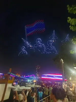 a crowd of people watching a light show at night at Muzachi home stay and canal in Bangkok Yai