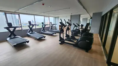 a gym with treadmills and ellipticals in a building at A3508 Monthly Condo Skytrain Minutes away Full Kitchen and Bath! in Bangkok