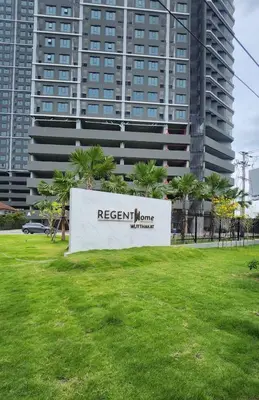 a sign in a park in front of a tall building at A3508 Monthly Condo Skytrain Minutes away Full Kitchen and Bath! in Bangkok