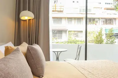 a bedroom with a bed and a window with a table at 2 Bedrooms 4 guests Private Floor at Sathorn in Bangkok