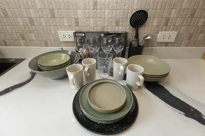 a table with plates and cups on a counter at 2 Bedrooms 4 guests Private Floor at Sathorn in Bangkok