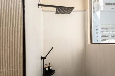 a bathroom with a shower with bottles of wine at Studio for 3 Guests with Kitchen at Center Sathorn in Bangkok