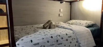 a bed with a teddy bear laying on it at Lesbase Women Hostel in Bangkok