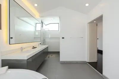 a white bathroom with a sink and a mirror at Thong Lo Modern Pool Villa In Center Of Bangkok in Bangkok