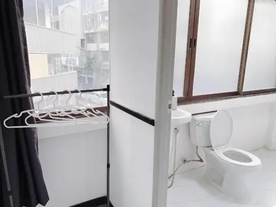 a white bathroom with a toilet and a window at xx GO INN MRT Hua Lamphong - วัดไตรมิตร in Samphanthawong