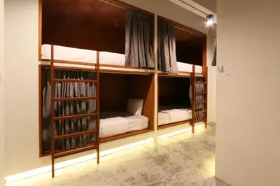 two bunk beds in a room with books at Once Again Hostel in Bangkok