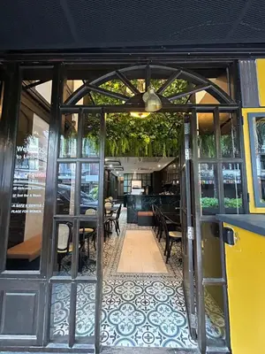 an open door of a restaurant with tables and chairs at Lesbase Female 8-Bed Room in Bangkok