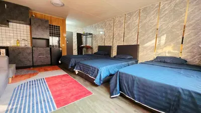 a bedroom with two beds and a kitchen in it at อิมแพ็ค เมืองทองธานี ห้องเช่ารายวัน เมืองทอง คอนโดเมืองทอง c9