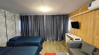 a room with two beds and a desk and a tv at อิมแพ็ค เมืองทองธานี ห้องเช่ารายวัน เมืองทอง คอนโดเมืองทอง c9
