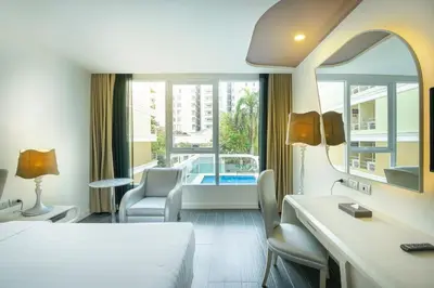 a hotel room with a bed and a view of a pool at Le Tada Parkview Hotel in Bangkok