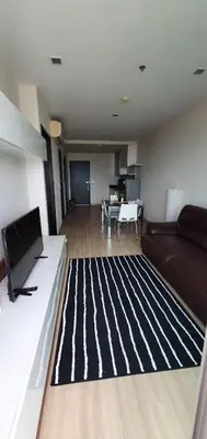 a living room with a couch and a black and white rug at Sky Walk Condo Spacious 2BR Near BTS Phra Khanong in Bangkok