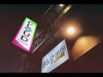 two signs on a pole next to a street light at Cloud 9 Lodge in Bangkok