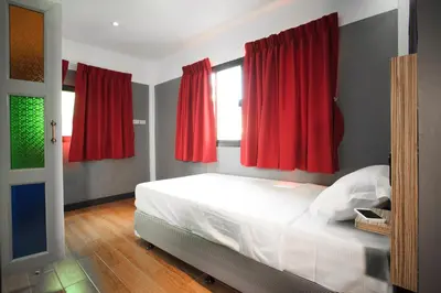 a bedroom with red curtains and a white bed at Cloud 9 Lodge in Bangkok