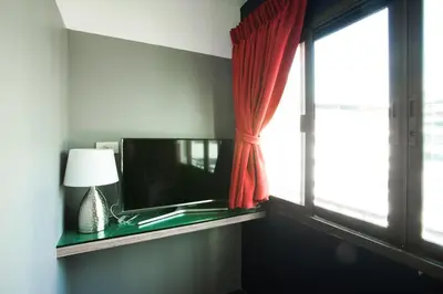 a room with a window with a lamp and a mirror at Cloud 9 Lodge in Bangkok