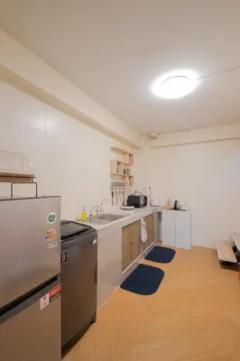 a kitchen with a refrigerator and a sink in a room at Warm & Cozy Family Home, Near BTS Punnawithi in Phra Khanong