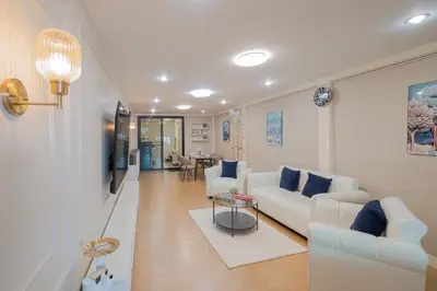 a living room with a white couch and a table at Warm & Cozy Family Home, Near BTS Punnawithi in Phra Khanong