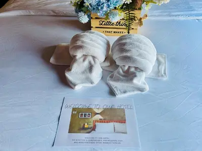two towels on a bed next to a magazine at Bangkok Phattanakan32 guest house in Bangkok