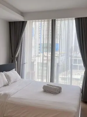a bed with a towel on it in front of a window at City life Nana - near Bumrungrad Hospital in Bangkok