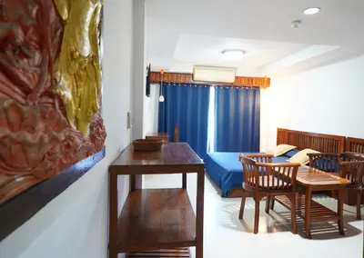 a room with a bed and a table and chairs at Sathorn Garden View in Bangkok