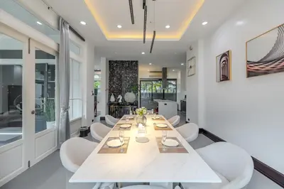 a dining room with a long table and white chairs at Thong Lo Luxury Pool Villa In Center Of Bangkok in Bangkok
