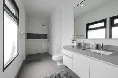 a white bathroom with a toilet and a sink at Thong Lo Sumptuous Double Pool Villa in Bangkok