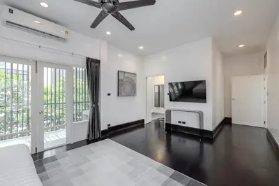 a bedroom with a ceiling fan and a flat screen tv at Thong Lo Sumptuous Double Pool Villa in Bangkok