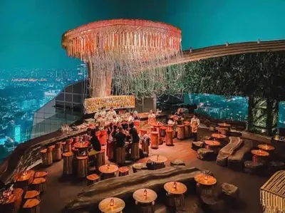 a group of people sitting at tables under a chandelier at Supreme Spacious 2-Bedroom in Prime Location! BTS Thonglor in Bangkok