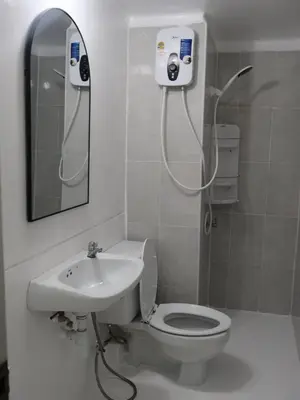 a bathroom with a shower and a toilet and a sink at Hi Impact Muangthong T9 in Nonthaburi