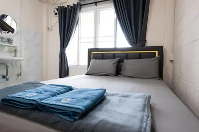 a bedroom with a bed with blue pillows on it at ดอนเมือง 201 Near DMK airport BTS Wat PhraSi in Bang Khen