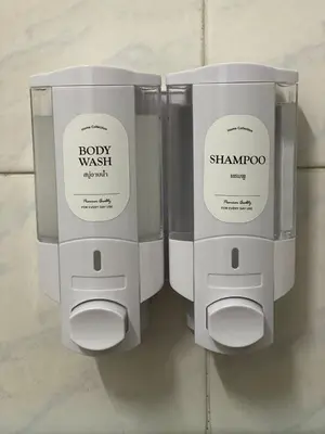 two white soap dispensers on a wall at PAMA'Pranakorn in Bangkok