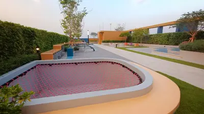 a swimming pool with a bench in a garden at Plum New West - Pool View in Ban Bang Krabu