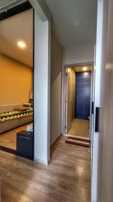 a hallway with a door leading to a bedroom at Plum New West - Pool View in Ban Bang Krabu