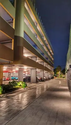 a parking lot of a parking garage at night at Plum New West - Pool View in Ban Bang Krabu