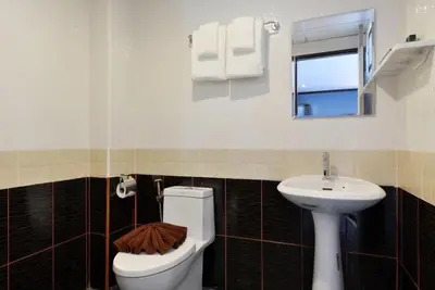 a bathroom with a toilet and a sink at THE BRETON Hotel in Ban O Pao