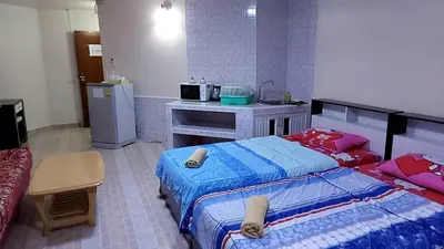 a bedroom with two beds and a kitchen with a sink at Smart Residence@Muengthongthani in Nonthaburi