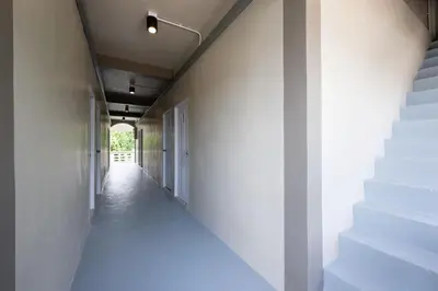 a hallway with white walls and white stairs at ดอนเมือง 203 Near DMK Airport BTS Wat PhraSi in Bang Khen
