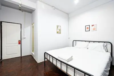 a white bedroom with a bed and a door at BAO The Giant Swing - เบา ศาลเจ้าพ่อเสือ ถนนตะนาว in Bangkok